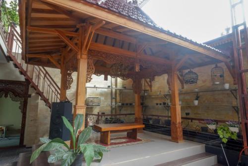a wooden pavilion with a wooden bench in a building at RedDoorz Syariah near Terminal Mendolo Wonosobo 2 in Ngasinan