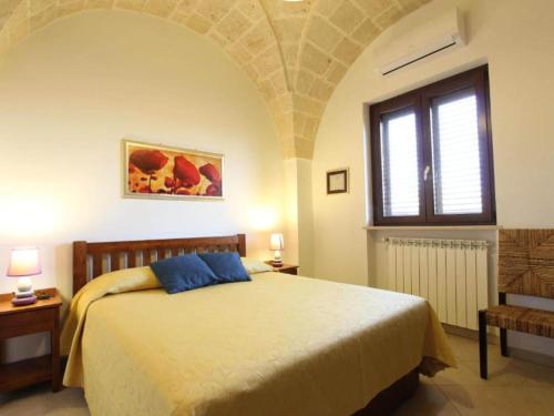 Un dormitorio con una cama grande y una ventana en Characteristic apartments in Salento just a few minutes from the sea, en Diso