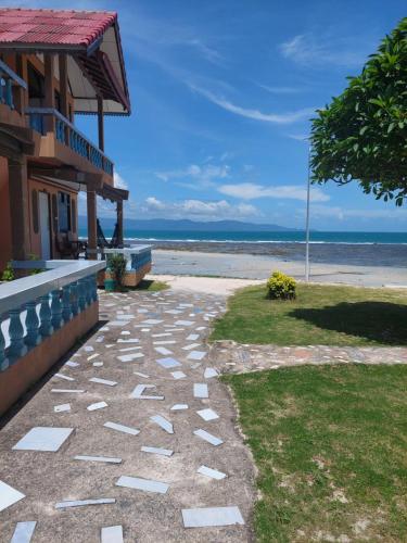 a walkway next to a building next to the beach at Charung Bungalows in Haad Rin