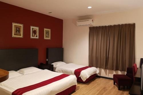 a hotel room with two beds and a window at OYO 89908 Hotel Kensington in Sandakan