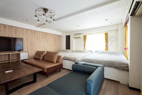 a bedroom with a bed and a couch and a tv at Evergreen Shinjuku Luxe #2m15 in Tokyo
