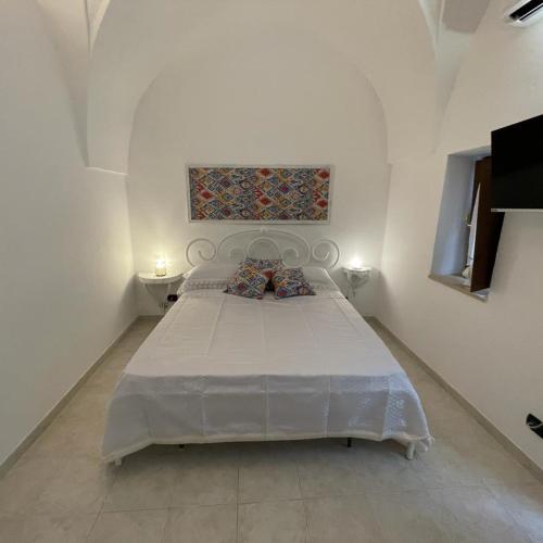 een witte slaapkamer met een groot bed in een kamer bij DOMUS LEPRARIUM in Leporano