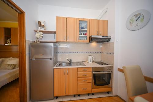 una cucina con frigorifero in acciaio inox e lavello di Apartment La Rocca a Dubrovnik