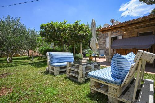 un paio di sedie e un ombrellone in un cortile di Apartment La Rocca a Dubrovnik