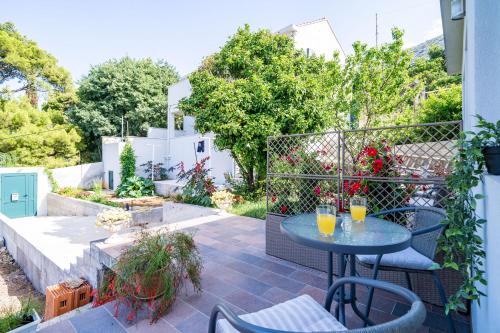 een patio met een tafel en stoelen bij Apartments Green Garden in Dubrovnik