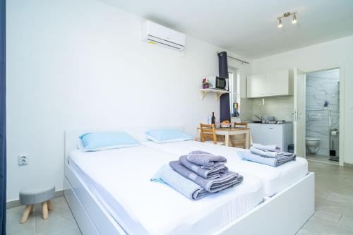 een slaapkamer met een wit bed en handdoeken bij Apartments Green Garden in Dubrovnik