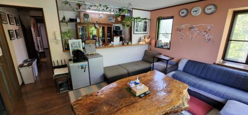 a living room with a blue couch and a table at Hakone Guest House gaku. in Hakone