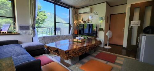 a living room with a couch and a table at Hakone Guest House gaku. in Hakone
