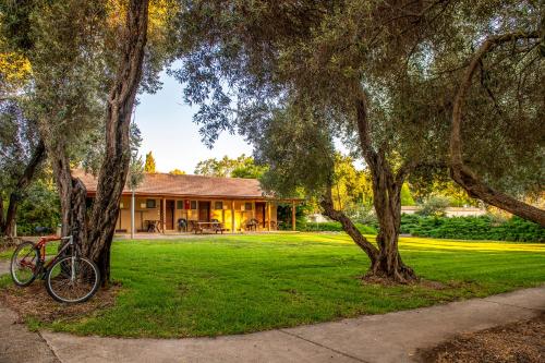 a house with a bike parked in the grass at כפר הנופש קיבוץ גדות Kibbutz Gadot Galilean Resort in Gadot