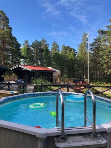 a large swimming pool with two metal bars in it at Timber cottages with jacuzzi and sauna near lake Vänern in Karlstad