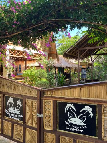 a fence with two signs in front of a restaurant at Meno Madia Bungalows in Gili Meno