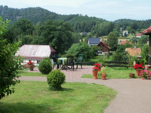 a patio with a table and chairs in a garden at Ferienpension Gabriele 61 in Kurort Gohrisch