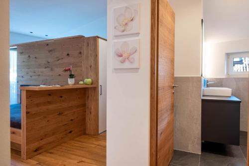 a bathroom with a wooden cabinet and a sink in a room at Luisl Hof - Apartment Pomum in Cornaiano