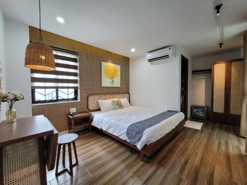 a bedroom with a bed and a table and a desk at Wings House in Da Nang