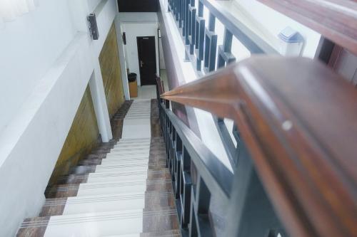 a stairway in a building with a person walking down it at Lia Homestay Syariah Pettarani Makassar Mitra RedDoorz in Makassar