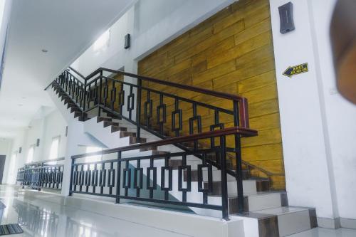 a staircase in a building with a wooden wall at Lia Homestay Syariah Pettarani Makassar Mitra RedDoorz in Makassar