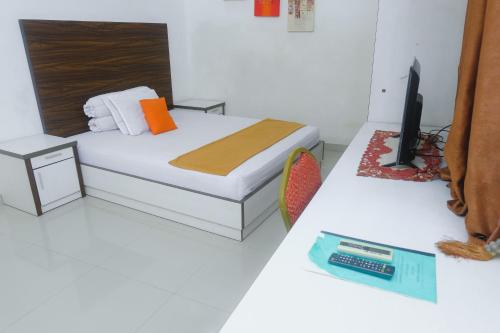 a bedroom with a bed and a tv on a table at Lia Homestay Syariah Pettarani Makassar Mitra RedDoorz in Makassar
