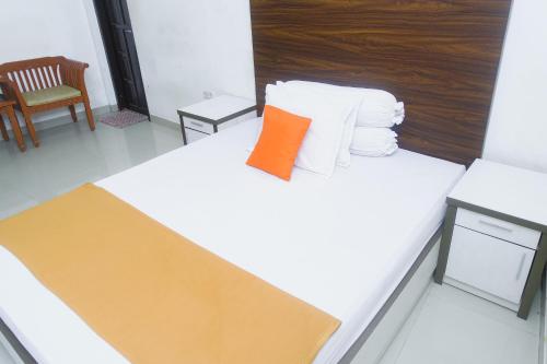 a room with a bed with an orange pillow on it at Lia Homestay Syariah Pettarani Makassar Mitra RedDoorz in Makassar
