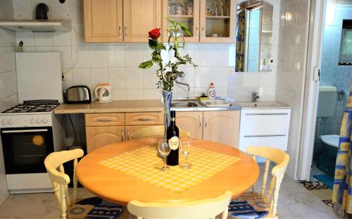 a kitchen with a table with a vase of flowers on it at Unicum Vendégház in Abádszalók