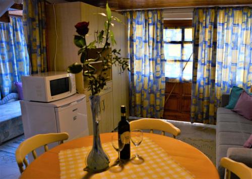 a table with two bottles and a vase with a flower at Unicum Vendégház in Abádszalók