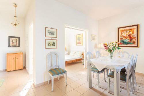 a white dining room with a table and chairs at Casa Nebari Seaside Retreats - Fully Equipped, Ideal Spot in Petalidhion
