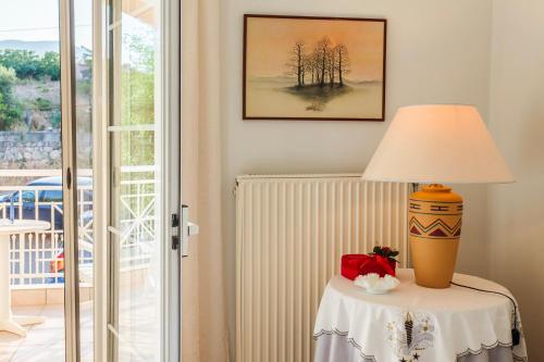 a lamp on a table next to a window at Casa Nebari Seaside Retreats - Fully Equipped, Ideal Spot in Petalidhion