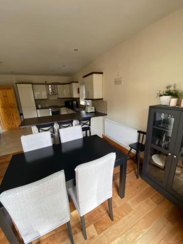 a kitchen and dining room with a table and chairs at Detached Town centre Villa in Cashel Sleeps 6 Private BBQ Area & Jacuzzi Bath in Cashel