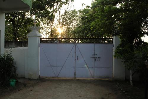 a white garage with a gate and a fence at "Priyadarshi Villa" Free pickup in ac car from Jasidih Railway station or Deoghar Airport in Deoghar