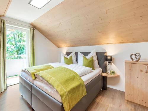 1 dormitorio con 1 cama grande con almohadas verdes en Alpine Holiday Home in Bramberg am Wildkogel with Garden, en Bramberg am Wildkogel