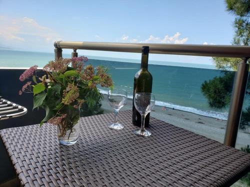 a table with a bottle of wine and two glasses at MIDIA Guest House in K'obulet'i