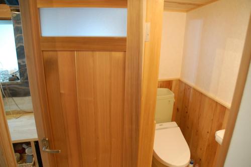 a small bathroom with a toilet and a wooden door at Tabinoya - Vacation STAY 69884v in Kakegawa