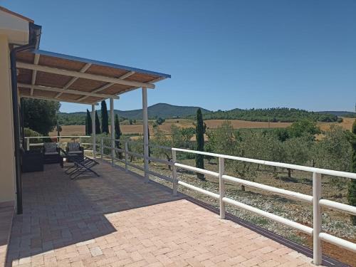 a porch of a house with a white fence at Agriturismo Il Poggio Rosso di Maremma in Manciano