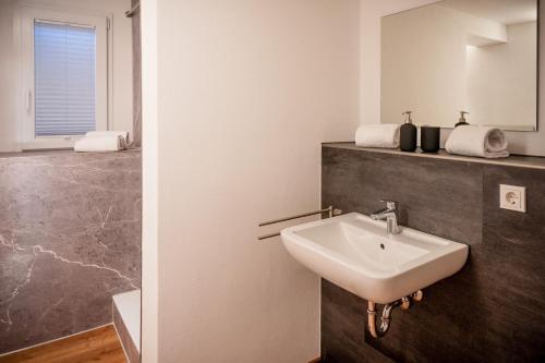 La salle de bains est pourvue d'un lavabo et d'un miroir. dans l'établissement Ferienwohnungen Reinhilde, à Traben-Trarbach