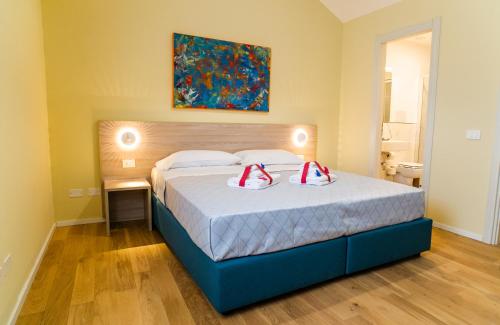 a bedroom with a bed with two red shoes on it at Historico Loft & Rooms Palazzo Adragna XIX in Trapani