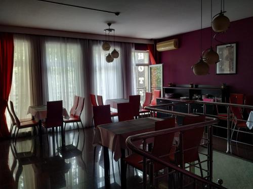 una sala da pranzo con tavoli, sedie e pareti viola di Gallery Hotel Baku a Baku