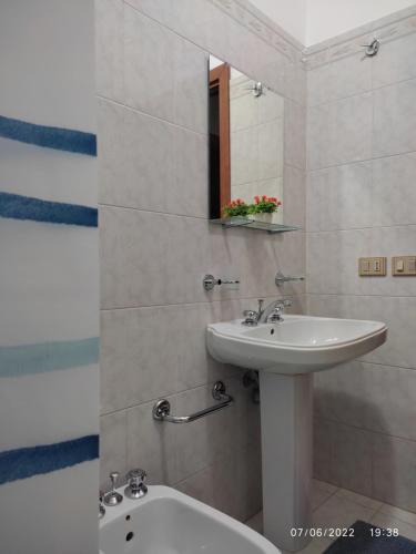La salle de bains est pourvue d'un lavabo, de toilettes et d'un miroir. dans l'établissement Villa Nonna Rosa, à Granelli