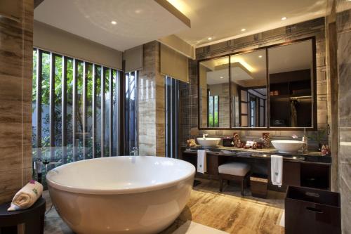 un bagno con due lavandini e una grande vasca di Banyan Tree Chongqing Beibei a Chongqing