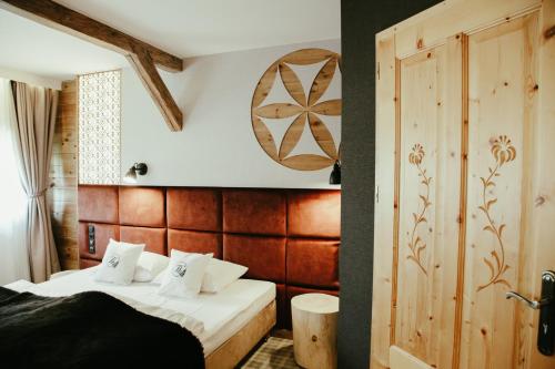 a bedroom with two beds and a wooden wall at Bajka Hotel & Resort in Grodziec