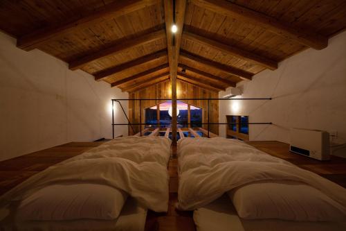 a large bed in a room with a wooden ceiling at HAKU 100-year-old Quaint Japanese Style Villa in Takayama