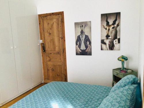 ニームにあるL’Authentique situé à 10 m des Arènes de Nîmesのベッドルーム1室(ベッド1台付)が備わります。壁には動物の写真が飾られています。