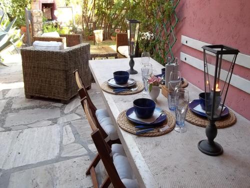 un tavolo di legno con piatti e bicchieri di Exclusive Holiday Home Argentarola a Porto Santo Stefano