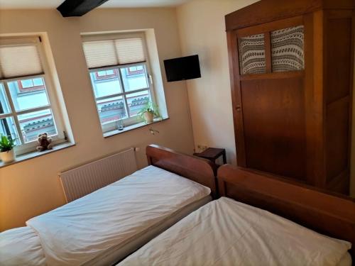 1 Schlafzimmer mit 2 Betten und 2 Fenstern in der Unterkunft Bremer Handelshaus Fremdenzimmer in Altmünden
