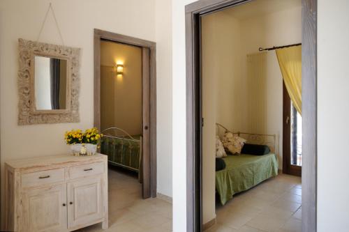 - une chambre avec un lit, une commode et un miroir dans l'établissement Il borgodellequerce CASA ULIVI PISCINA PRIVATA, à Martina Franca