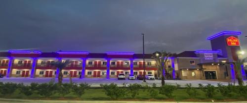 a hotel with blue lights in a parking lot at PALACEINN-ARCOLA in Rosharon