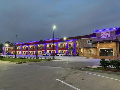 a now open sign on a building in a parking lot at PALACEINN-ARCOLA in Rosharon