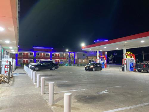 two cars parked at a gas station at night at PALACEINN-ARCOLA in Rosharon