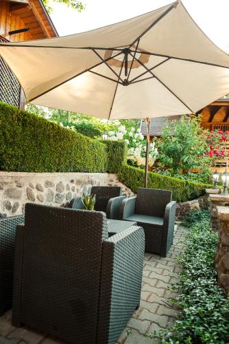 a patio with an umbrella and some chairs and anzai at Casa Edy in Sovata