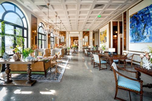 eine Lobby mit Tischen und Stühlen in einem Gebäude in der Unterkunft L'amor Boutique Hotel Quy Nhơn in Quy Nhon