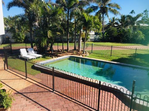 a swimming pool with a fence around it at Sandy toes in Yeppoon