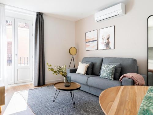 a living room with a couch and a table at Limehome Madrid Calle de Fomento - estancia temporal in Madrid